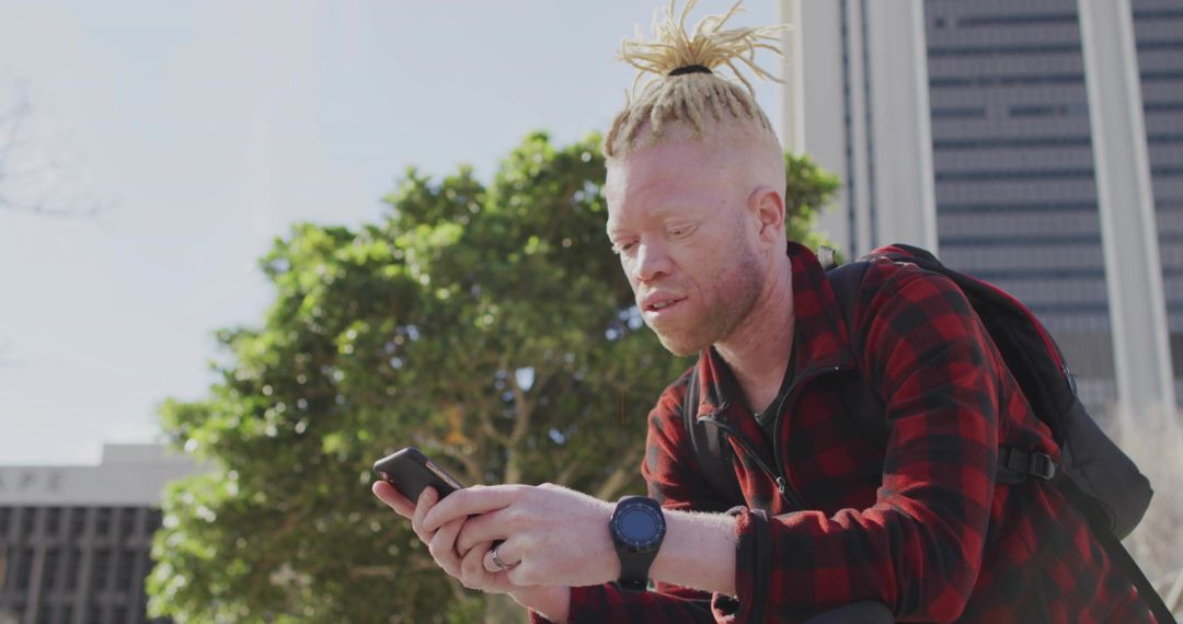 Man in Flannel with Smartphone in Urban Plaza in Spring