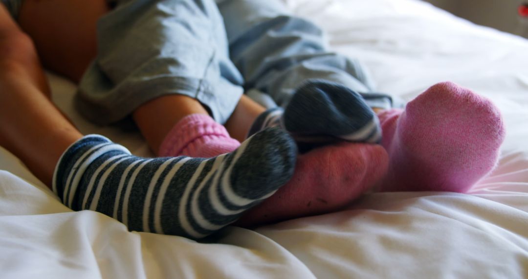 Cozy Feet in Colorful Socks Relaxing on Bed - Free Images, Stock Photos and Pictures on Pikwizard.com