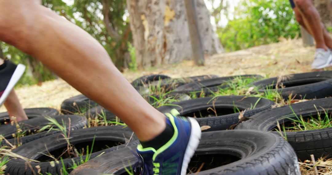 Athletes Running Through Tire Obstacle During Outdoor Training - Free Images, Stock Photos and Pictures on Pikwizard.com