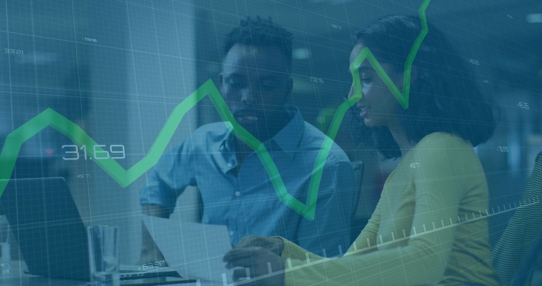 Professionals reviewing financial data on laptop with rising green stock chart overlay