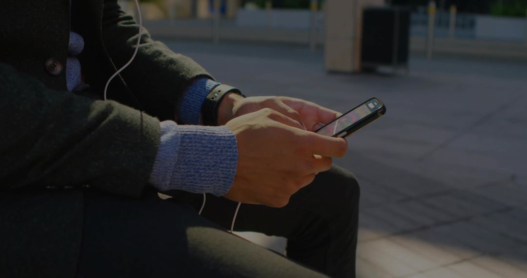 Modern Lifestyle: Man Engaged with Smartphone in Urban Setting