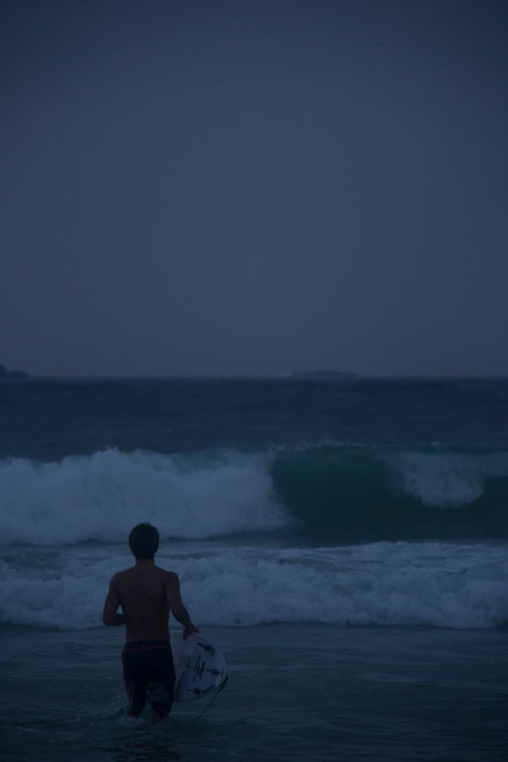 Surfer Heading into Ocean at Dusk - Free Images, Stock Photos and Pictures on Pikwizard.com