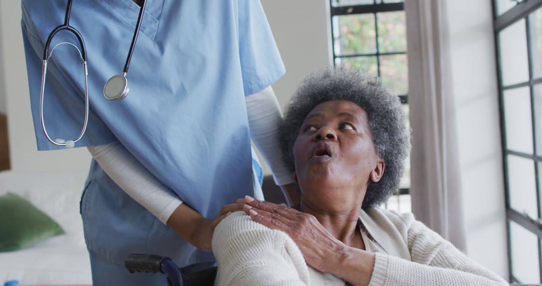 Caring african american female doctor helping senior african american female - Free Images, Stock Photos and Pictures on Pikwizard.com