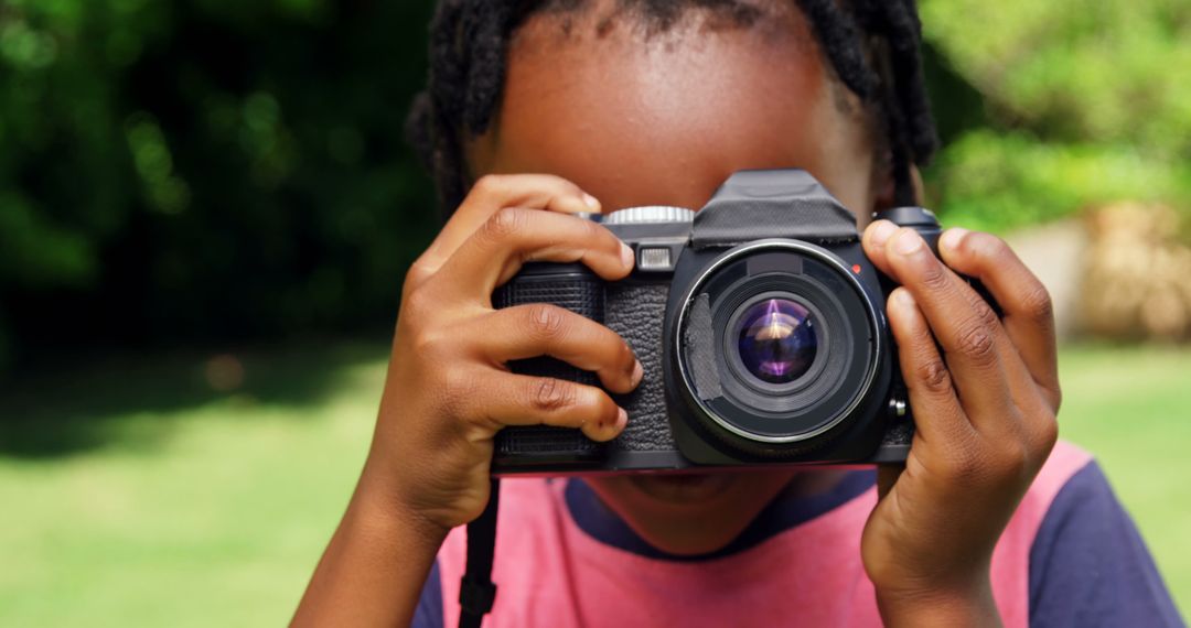 Young Child Holding Camera Outdoors - Free Images, Stock Photos and Pictures on Pikwizard.com