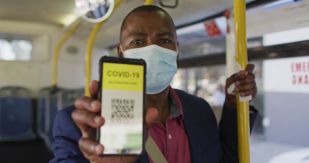 Man with Mask Showing COVID-19 Vaccine Passport on Bus