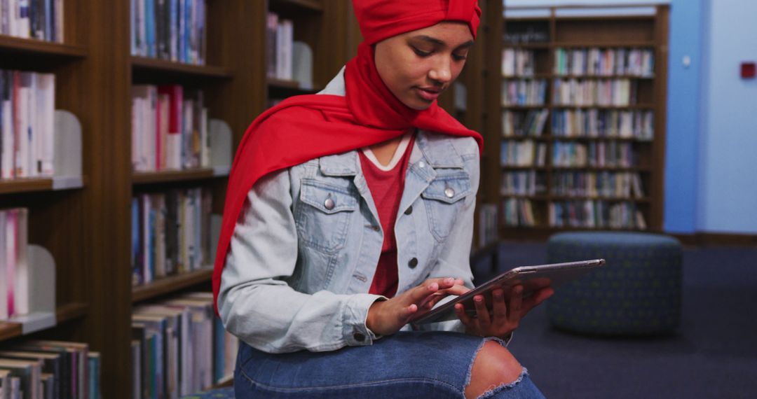 Young Woman in Headscarf Using Digital Tablet at Library - Free Images, Stock Photos and Pictures on Pikwizard.com