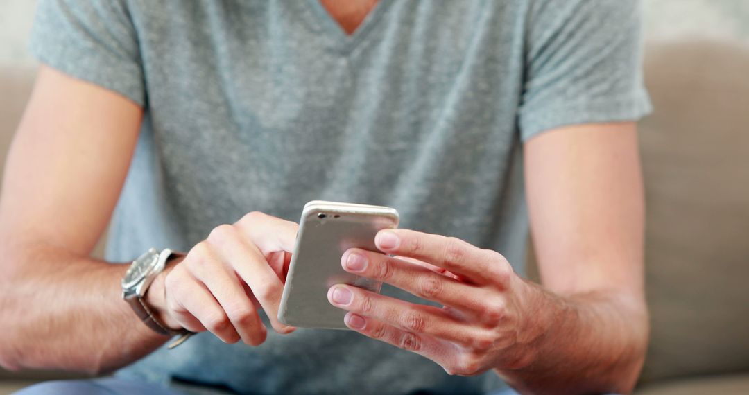 Man Using Smartphone While Sitting on Couch - Free Images, Stock Photos and Pictures on Pikwizard.com