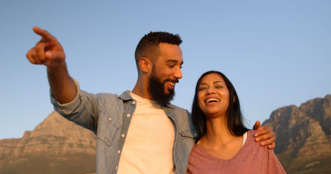 Happy Couple Sharing Joyful Moment Outdoors with Mountains in View
