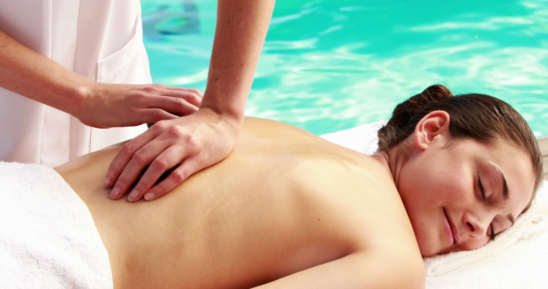 Woman Receiving Relaxing Massage by Poolside on Sunny Day - Free Images, Stock Photos and Pictures on Pikwizard.com