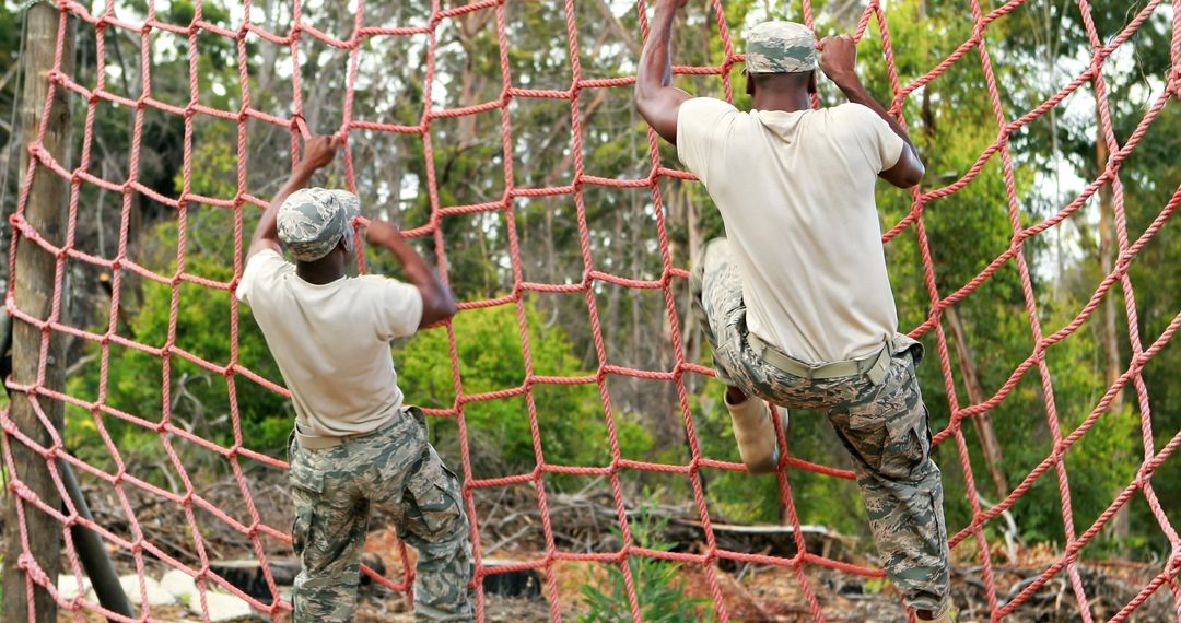 Military Personnel in Obstacle Course Challenge with Rope Net