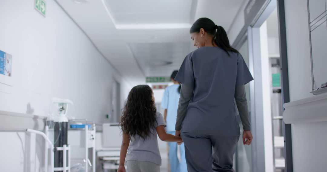 Biracial girl and female surgeon walking and holding hands in hospital - Free Images, Stock Photos and Pictures on Pikwizard.com