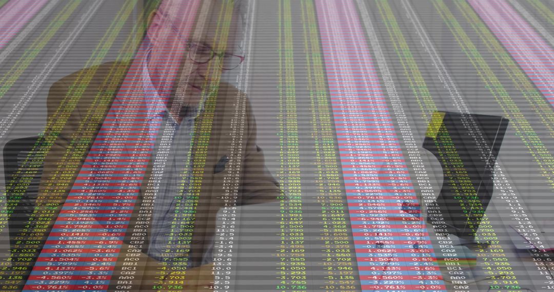 Senior analyst analyzing market data overlaying office workspace with laptop and documents