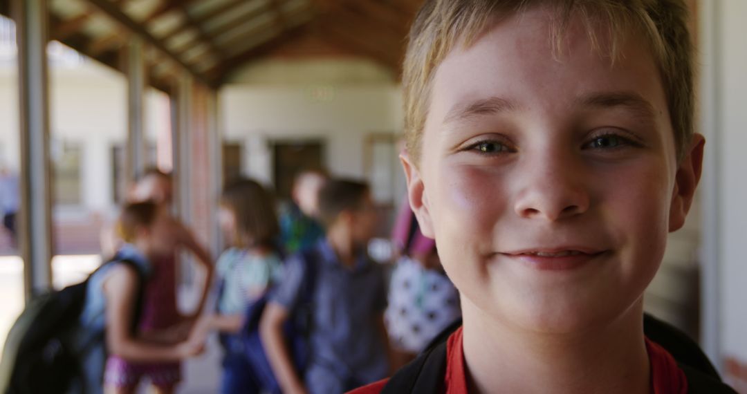 Happy Child Smiling at School Hallway with Friends in Background - Free Images, Stock Photos and Pictures on Pikwizard.com