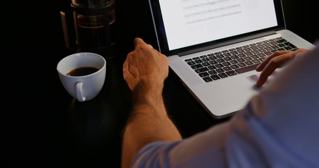 Professional Engaged in Laptop Work with Coffee