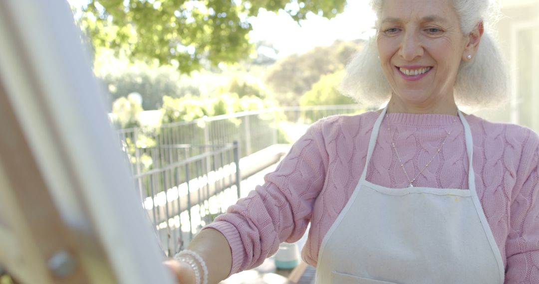 Senior Woman Painting Outdoors in Sunny Garden - Free Images, Stock Photos and Pictures on Pikwizard.com