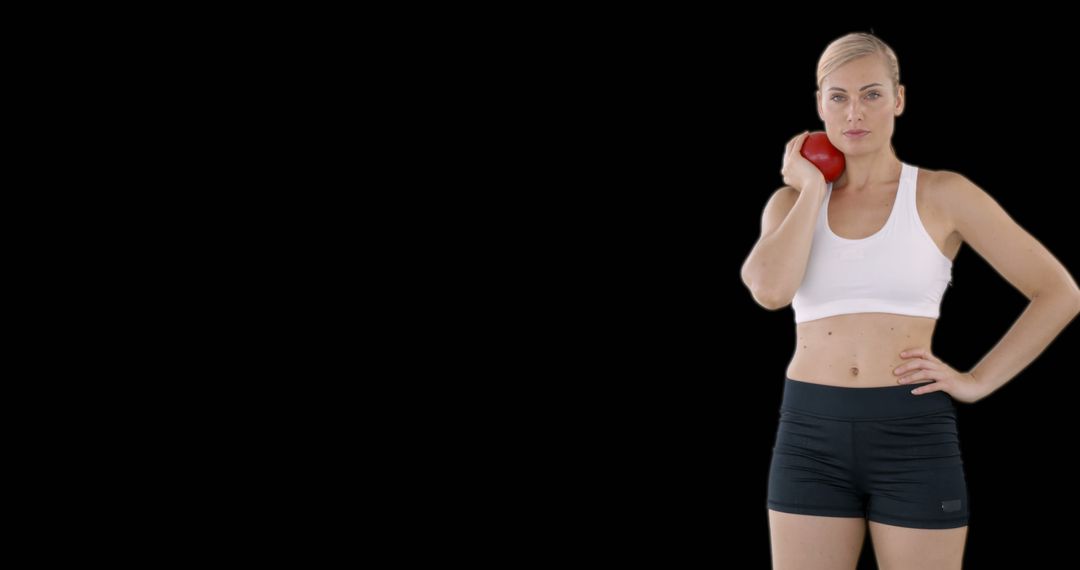 Determined Female Athlete Posing with Shot Put on Shoulder Against Black Background - Free Images, Stock Photos and Pictures on Pikwizard.com