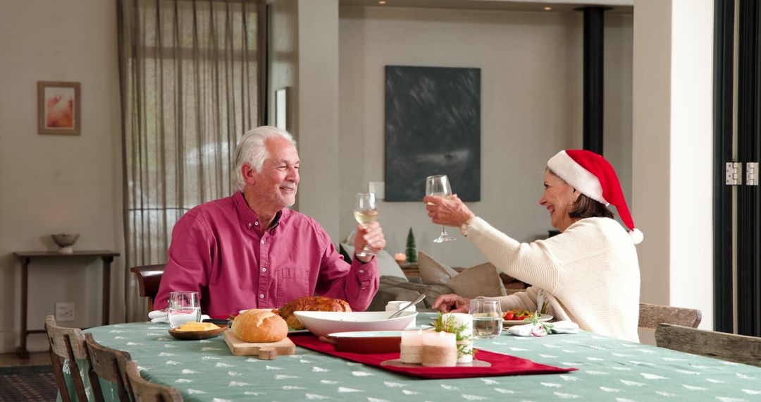 Senior couple toasting at festive holiday dinner table at home