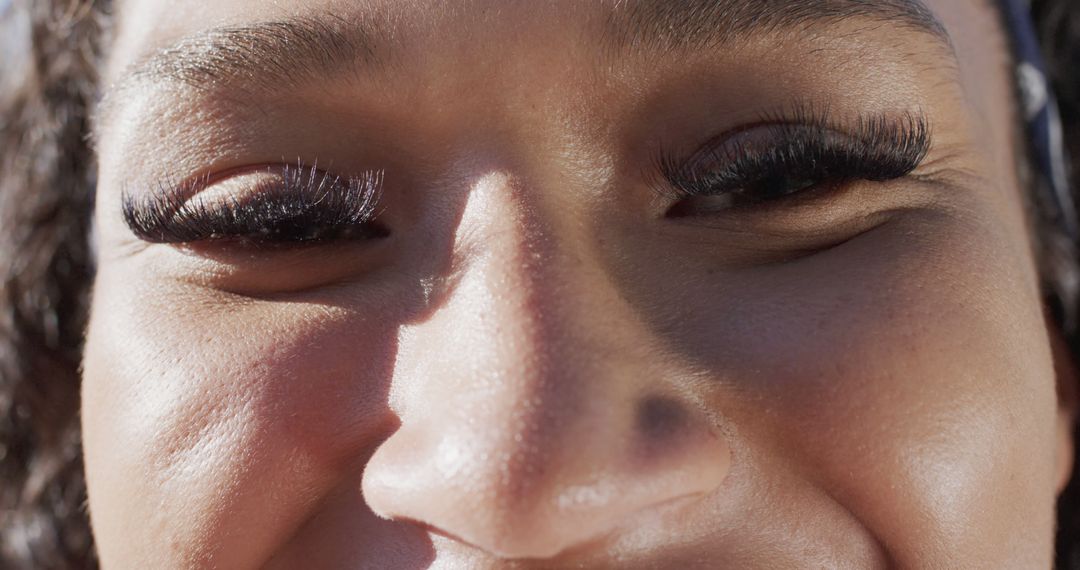 Close-Up of Smiling Woman with Long Eyelashes Enjoying Sunlight - Free Images, Stock Photos and Pictures on Pikwizard.com