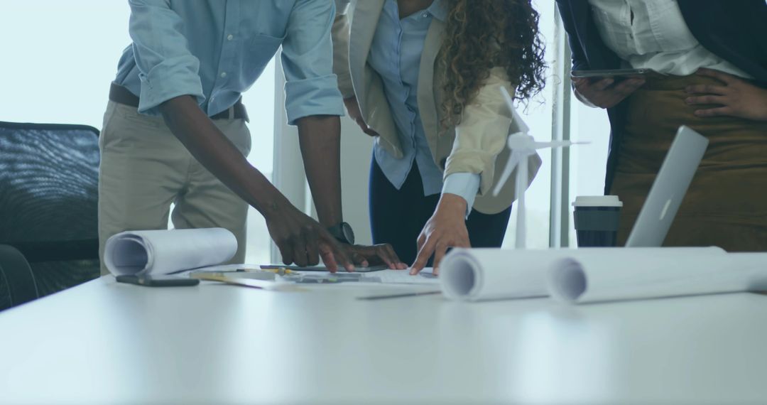 Professionals Collaborating on Architectural Plans in Office Setting