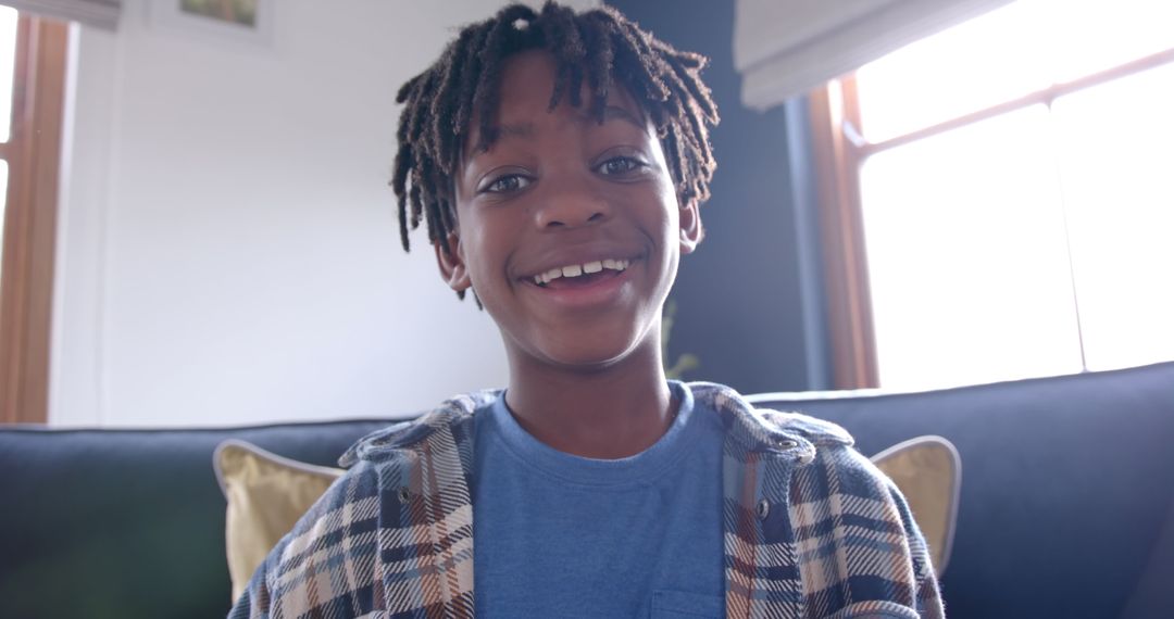 Joyful African American Boy Sitting on Sofa for Video Call at Home