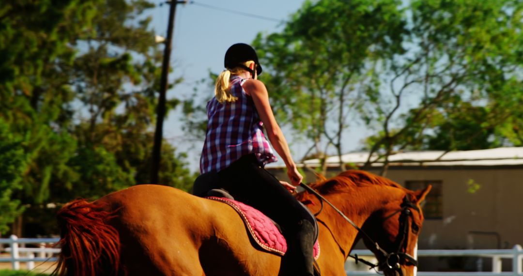 A young Caucasian woman enjoys horseback riding on a sunny day, with copy space - Free Images, Stock Photos and Pictures on Pikwizard.com