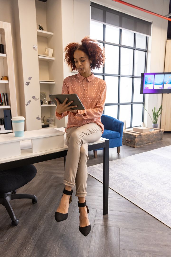Confident Professional Woman Utilizing Tablet in Modern Office Env.