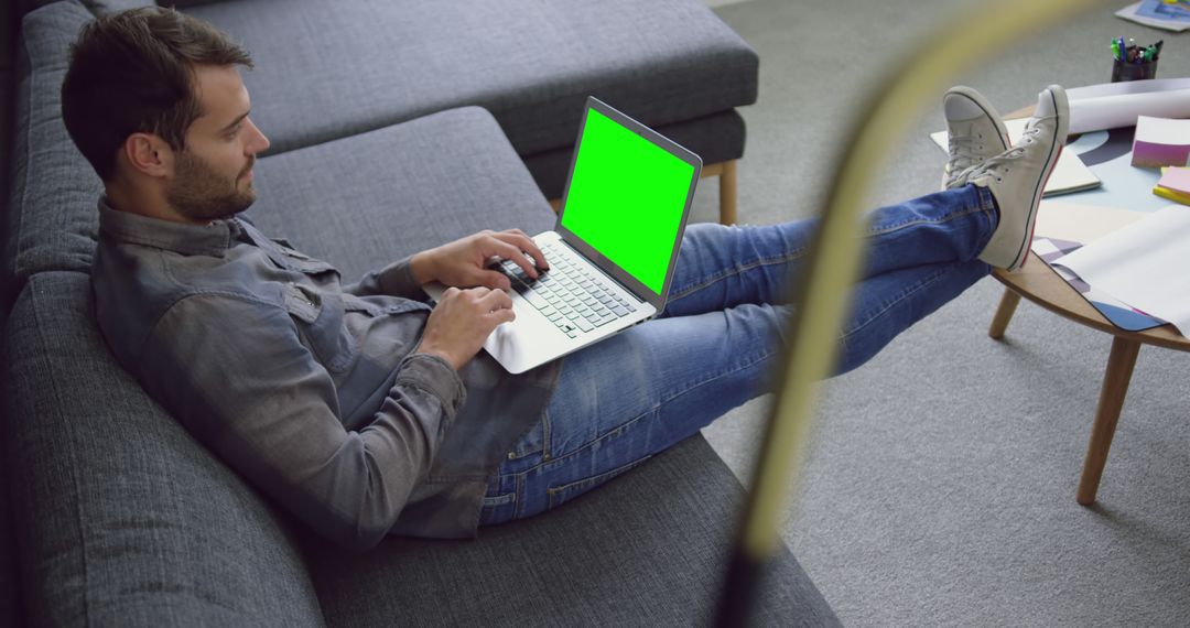 Man Using Laptop with Green Screen on His Lap at Home - Free Images, Stock Photos and Pictures on Pikwizard.com