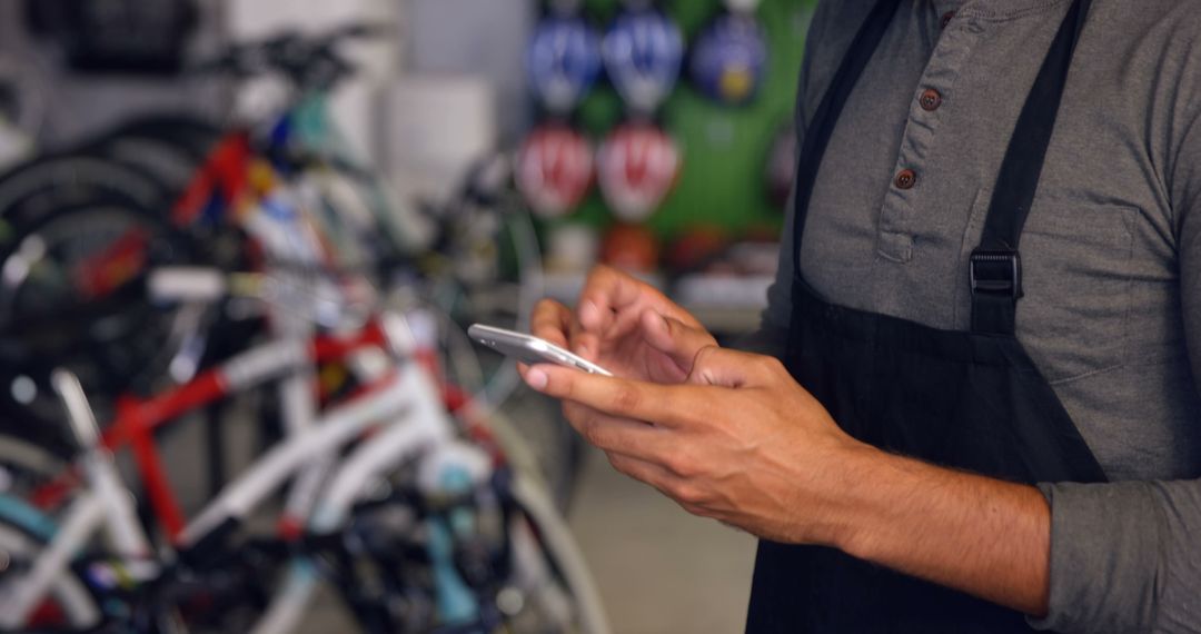 Bike Shop Employee Using Smartphone for Online Order - Free Images, Stock Photos and Pictures on Pikwizard.com