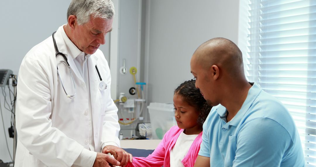 Doctor Examining Young Girl's Arm with Concerned Father Nearby - Free Images, Stock Photos and Pictures on Pikwizard.com