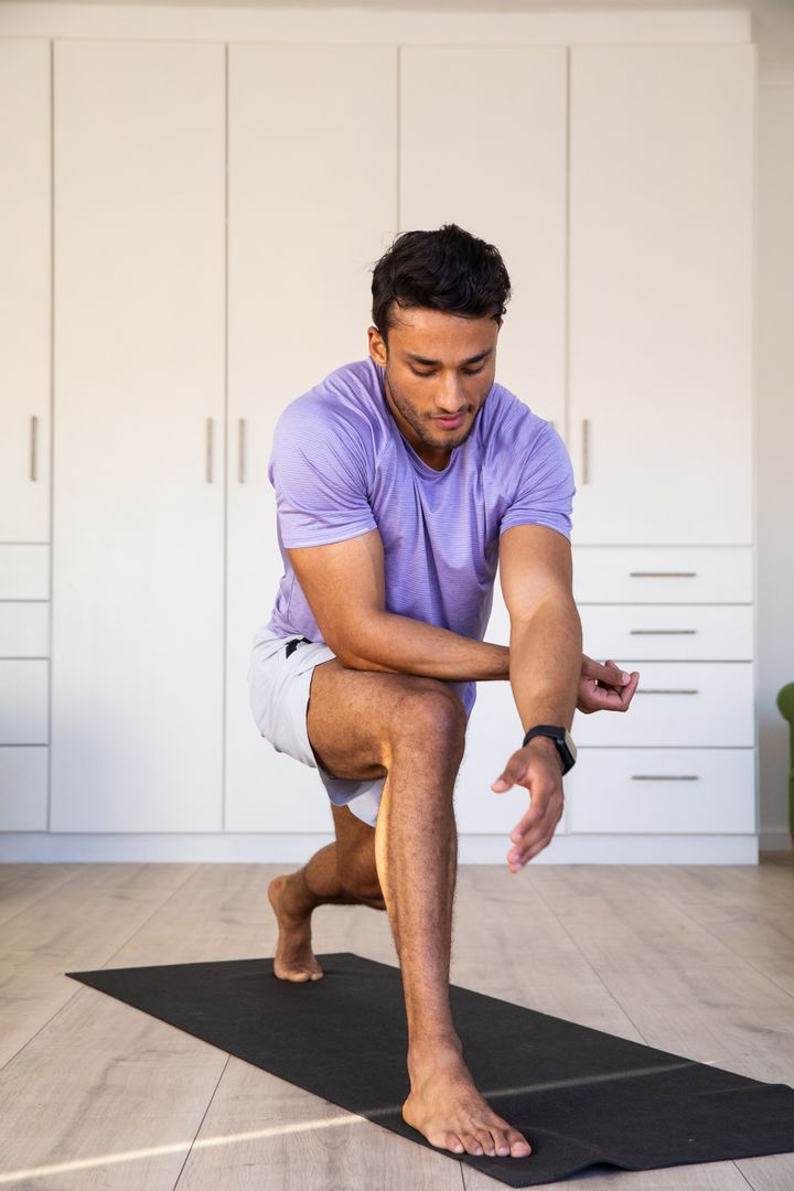 Middle Eastern Man Practicing Lunges in Home Gym for Fitness Routine