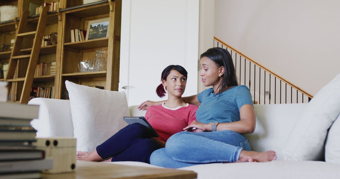 Comfortable Family Moment with Sisters Using Tablet at Home
