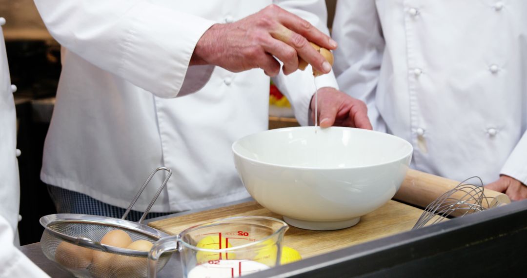 Close-Up of Chefs Cracking Eggs into Bowl in Professional Kitchen - Free Images, Stock Photos and Pictures on Pikwizard.com