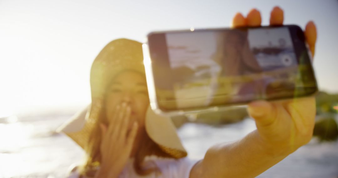 Woman Taking Beach Selfie with Smartphone, Blowing Kisses - Free Images, Stock Photos and Pictures on Pikwizard.com