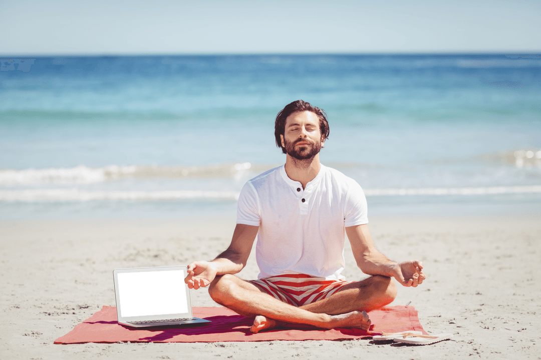 Man Meditating with Laptop on Transparent Beach in Sunshine