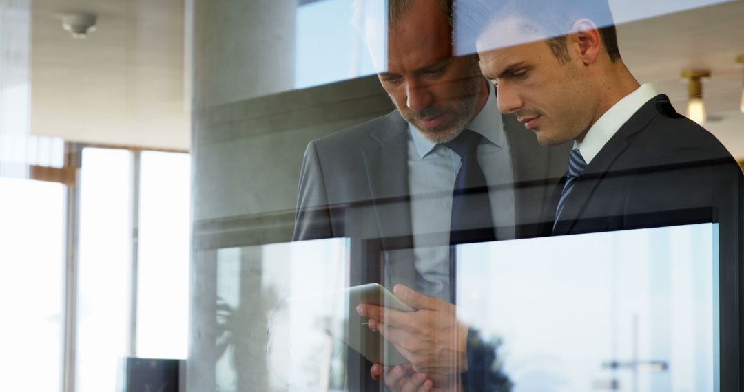 Businessmen Collaborating with Tablet in Modern Setting