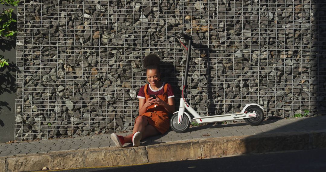 Young Woman Relaxing with Smartphone Near Electric Scooter - Free Images, Stock Photos and Pictures on Pikwizard.com