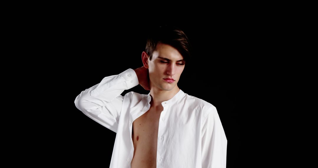 Pensive Young Man in Open White Shirt on Black Background - Free Images, Stock Photos and Pictures on Pikwizard.com