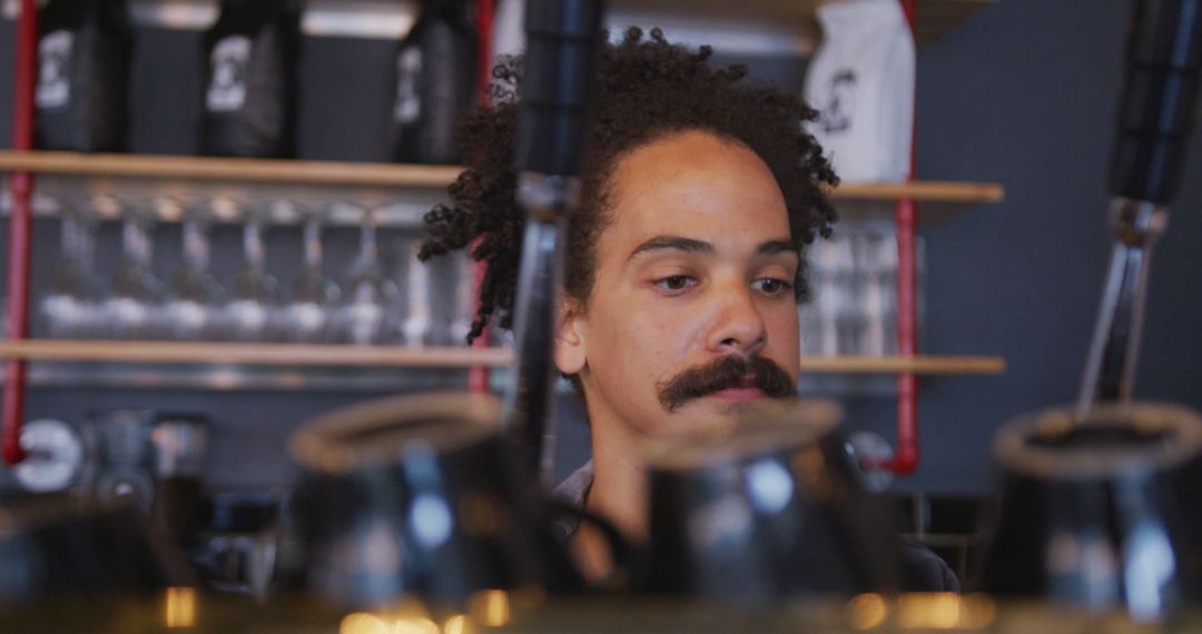 Barista with Moustache Making Coffee at Café Counter