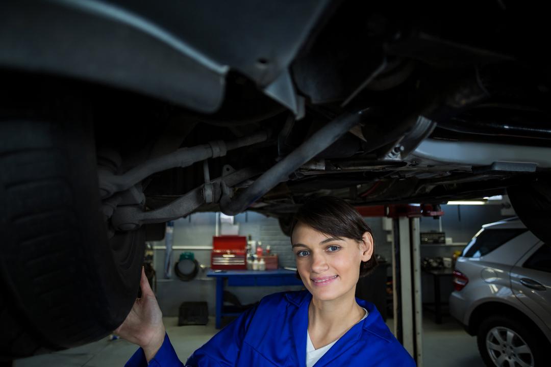 Female Mechanic Examining Car Wheel in Repair Garage - Free Images, Stock Photos and Pictures on Pikwizard.com