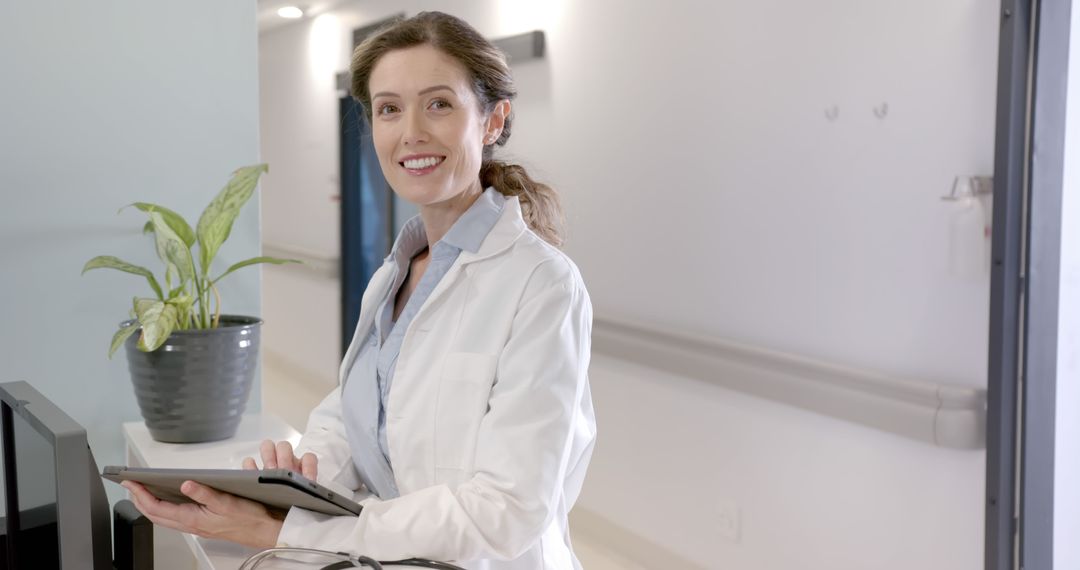 Smiling Female Doctor Using Digital Tablet in Hospital - Free Images, Stock Photos and Pictures on Pikwizard.com