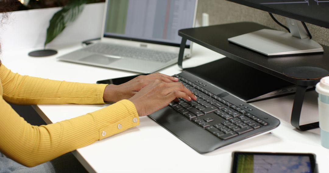 Professional Man Typing on Wireless Keyboard in Modern Office Setting