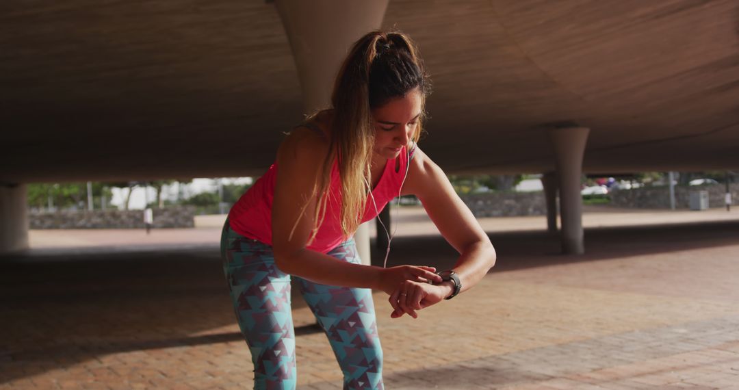 Active Woman Wearing Sporty Outfit Checking Time on Smartwatch - Free Images, Stock Photos and Pictures on Pikwizard.com