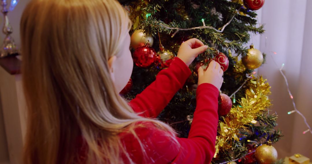 Young Girl Decorating Christmas Tree with Baubles and Tinsel - Free Images, Stock Photos and Pictures on Pikwizard.com