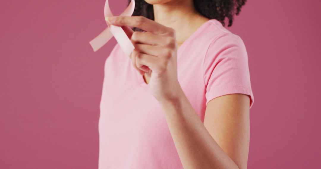 Image of biracial woman holding her pink breast cancer ribbon - Free Images, Stock Photos and Pictures on Pikwizard.com