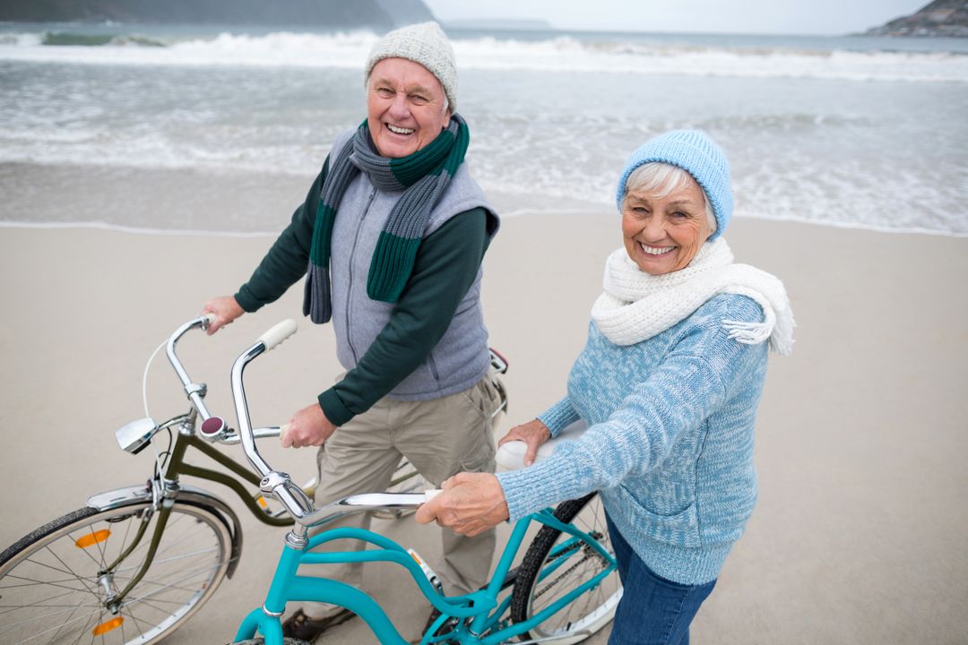 Portrait of senior couple standing with bicycles on the beach  - Free Images, Stock Photos and Pictures on Pikwizard.com