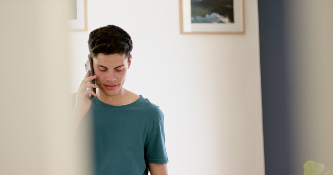 Young Man Talking on Smartphone at Home