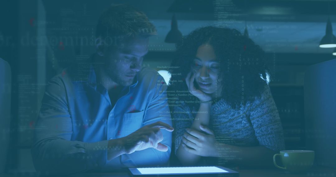 Male and Female Colleagues Collaborating on Tablet in Office with Low Light - Free Images, Stock Photos and Pictures on Pikwizard.com