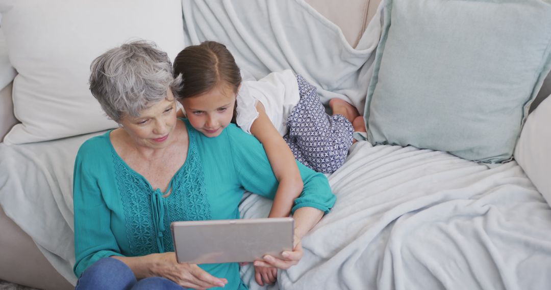 Grandmother and Granddaughter Using Tablet at Home - Free Images, Stock Photos and Pictures on Pikwizard.com