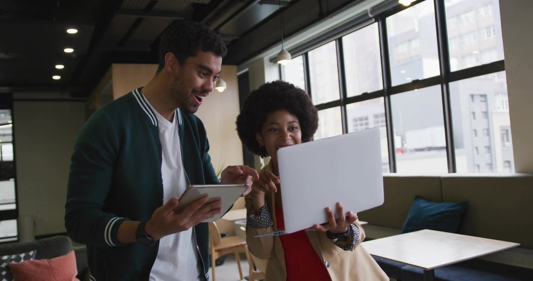 Colleagues Collaborating on Digital Devices in Modern Co-working Space