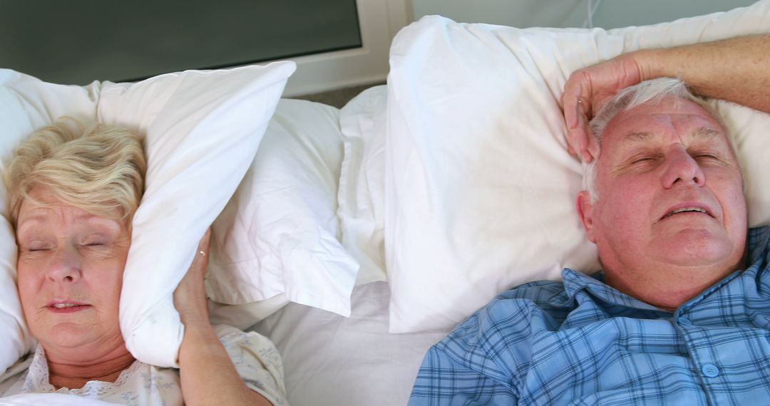 Elderly Couple Sleeping in Bed, Woman Covering Ears with Pillow - Free Images, Stock Photos and Pictures on Pikwizard.com